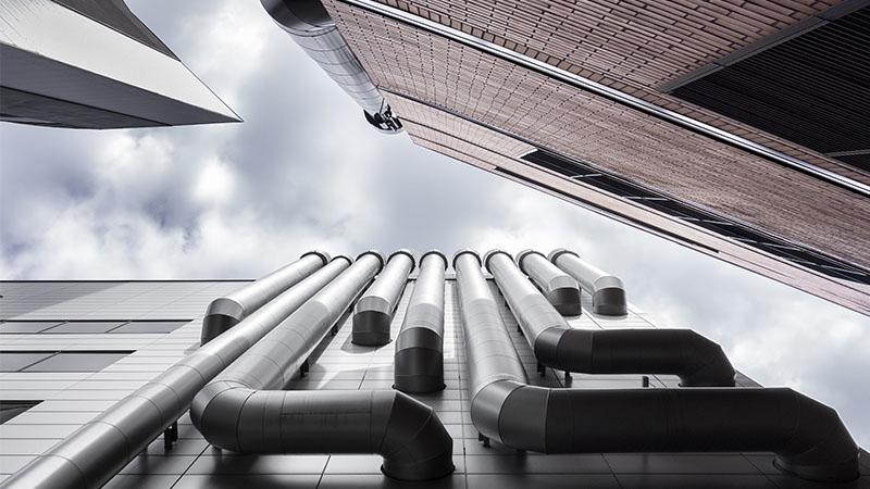 Vue en contre-plongée de trois tuyaux de ventilation de gratte-ciel. Mur de briques, conduit d'aération ou conduit d'air.