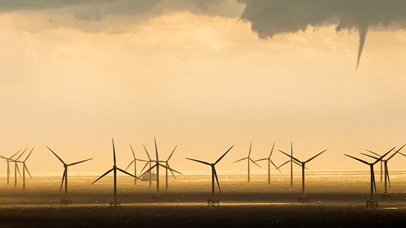 Closeup on tornado hitting wind farm