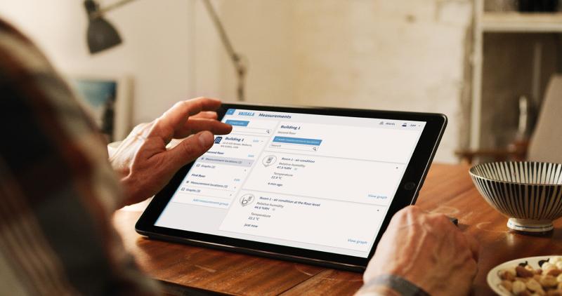 Person holding tablet with Jade Smart Cloud user interface.