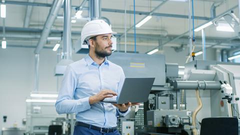 Man with laptop in industrial setting