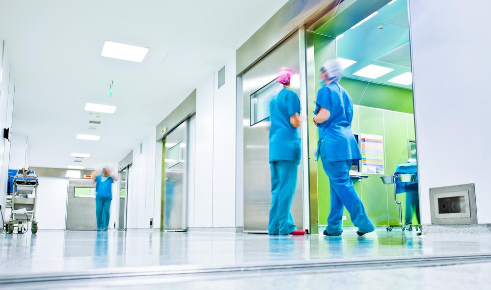 People wearing scrubs in a hospital hallway