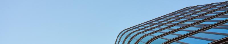Modern-building-with-curved-glass-facade-reflecting-sky